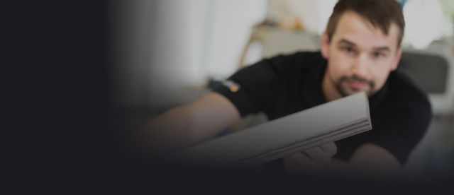 A photo of a woodworker displaying a panel with freshly edged finish