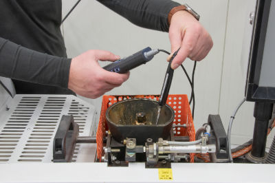 An image of an engineer checking the temperature of the gluepot